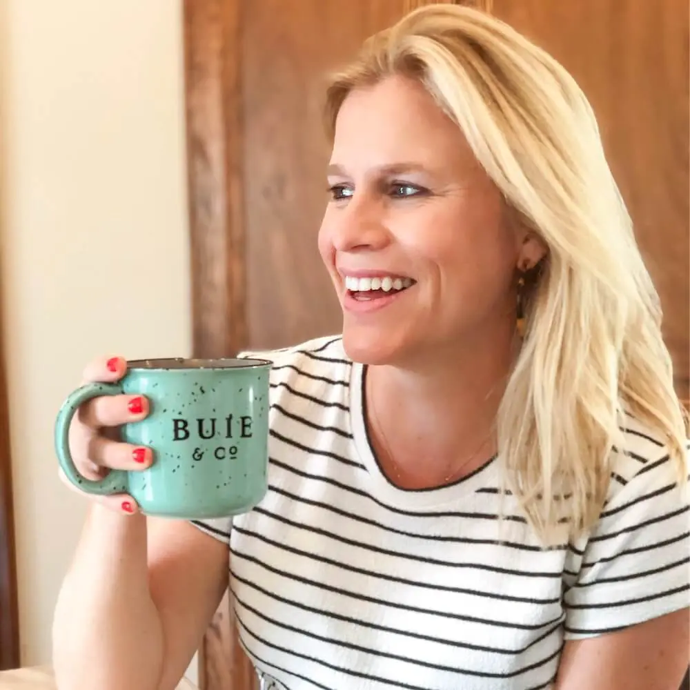 Woman holding buie mug while smiling