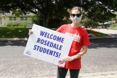 Student holding welcome sign at AISD event